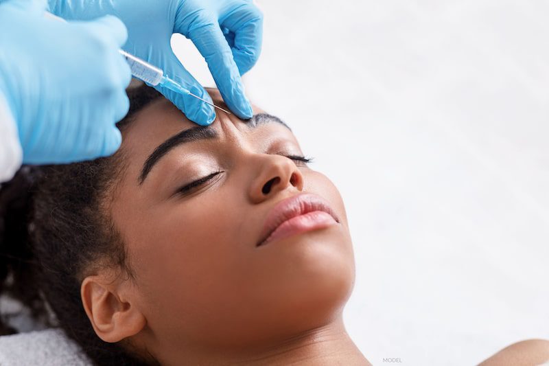 Beautiful woman having BOTOX® Cosmetic injection in between her eyebrows